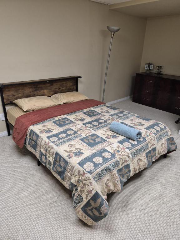 a bedroom with a bed with a quilt on it at Modern Basement Suit west side with Room 4 in Edmonton