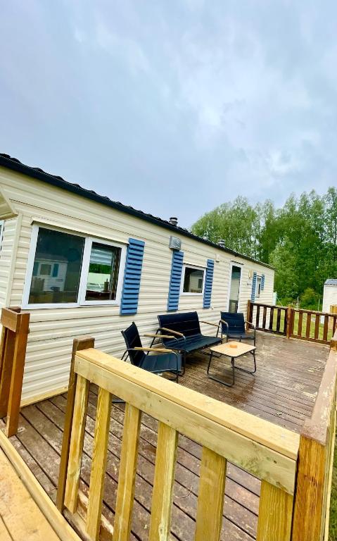 a deck with chairs and a table and a house at Bungalow Katalina in Bourbourg