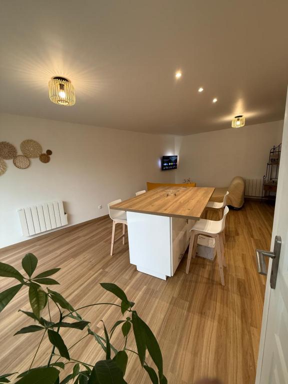 a dining room with a wooden table in a room at Le Grimpeur in Achères-la-Forêt