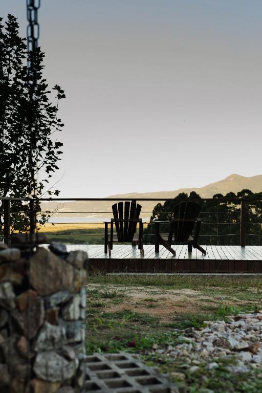 a park bench with a view of the ocean at Oliveira mountain House in Tijucas
