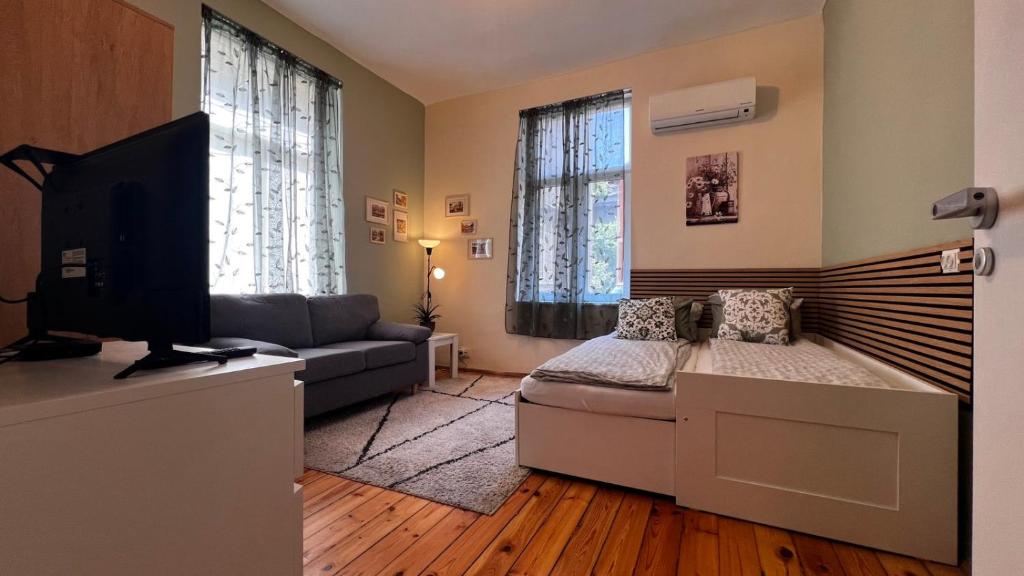 a living room with a bed and a couch and a television at Alice house in Sofia