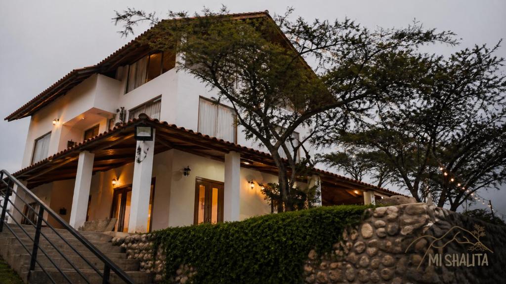 a white house with stairs in front of it at Mi Shalita in Santa Cruz