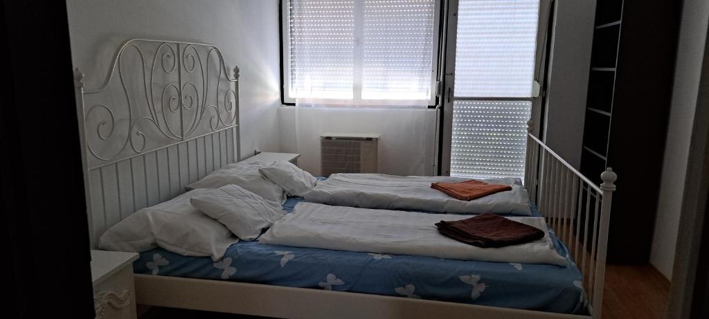 two twin beds in a room with a window at Bluebird apartman in Zalakaros