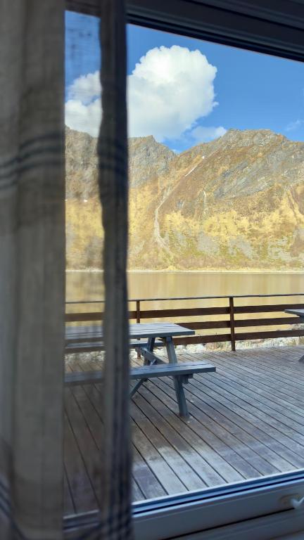 a picnic table on a deck with a view of a mountain at Salt&Stone in Gryllefjord