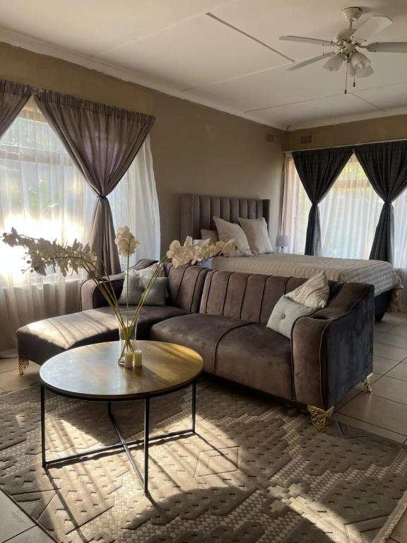 a living room with a couch and a coffee table at Garden Cottage - Self Catering in Amanzimtoti