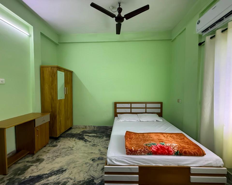 a bedroom with a bed and a ceiling fan at Southern Residency in Ferokh