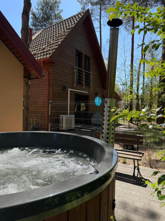 a large hot tub in front of a house at Całoroczny Domek nad Jeziorem in Białka