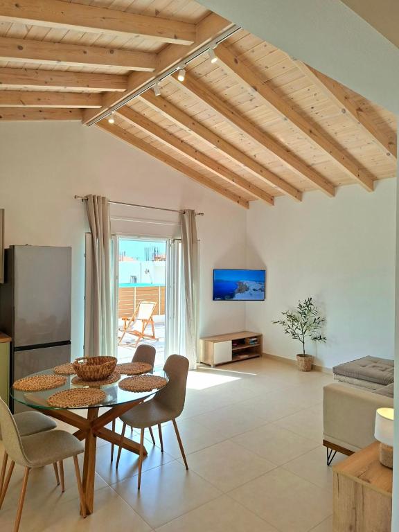a living room with a table and chairs and a television at Villa Eleni Apartment no2 in Agios Gordios
