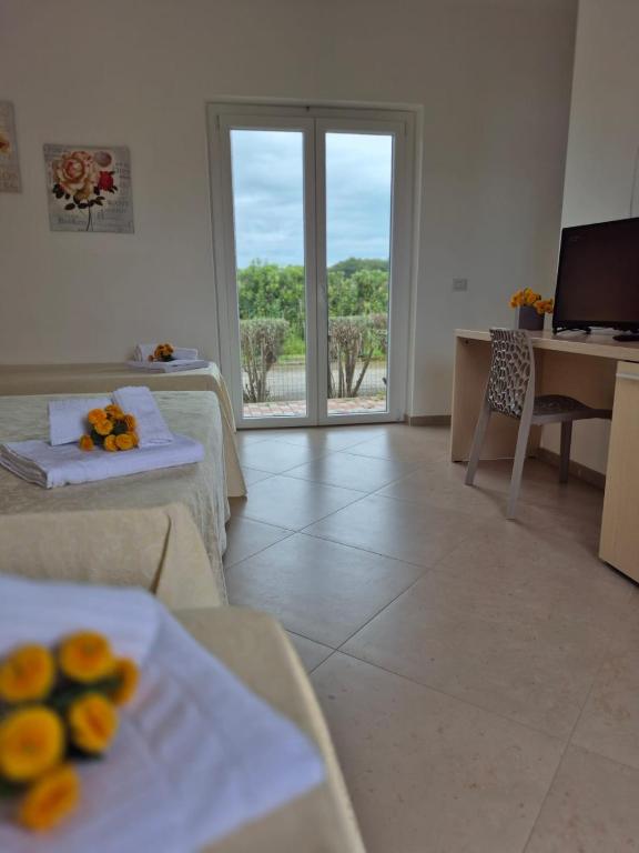 a room with two beds and a table with oranges on it at Albergo Athena Mare in Sibari