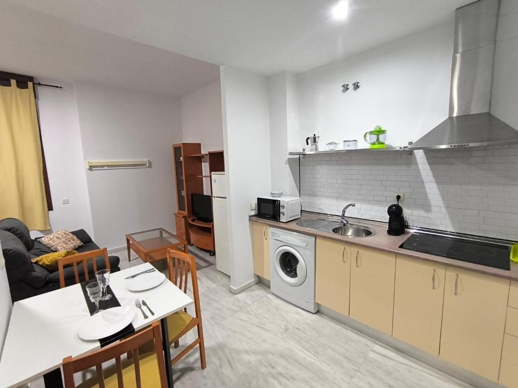 a kitchen with a sink and a table and a microwave at Lux Sevilla Elegance in Seville