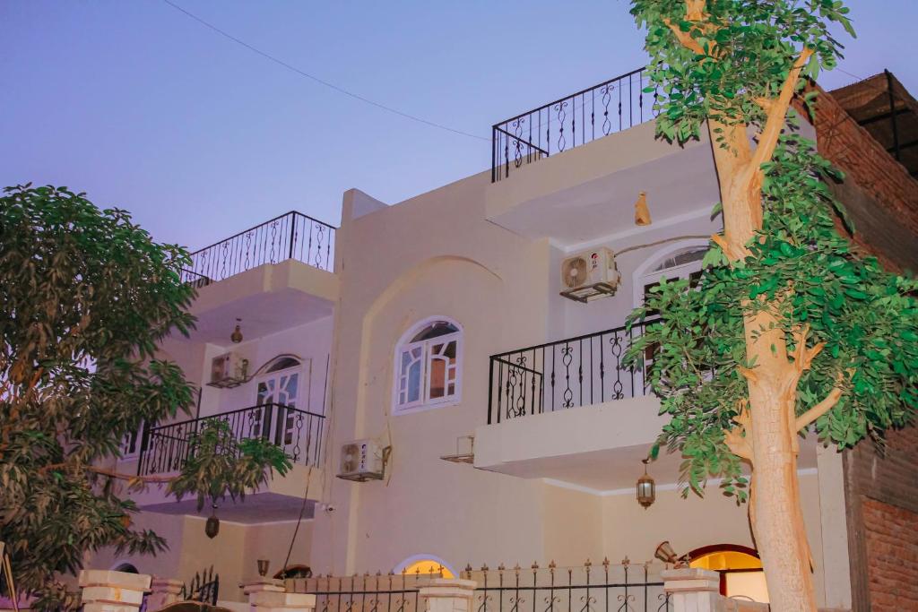 a white building with stairs and a tree at Villa Abo Ishak in Luxor