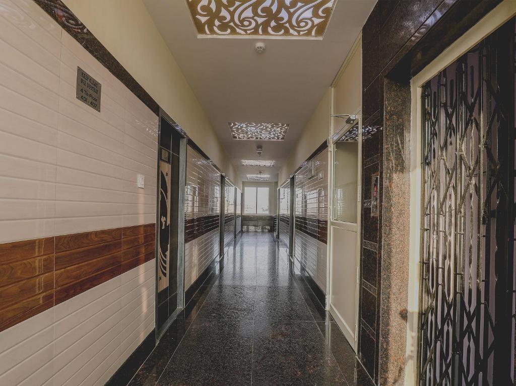 a corridor of a hallway with white walls and a ceiling at Super Hotel O Src Grand in Vijayawāda
