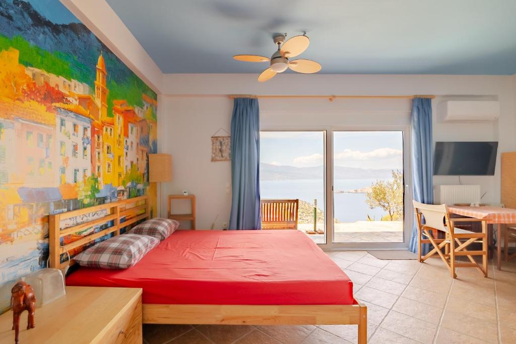 a bedroom with a red bed and a view of the ocean at Fragola in Pefkali