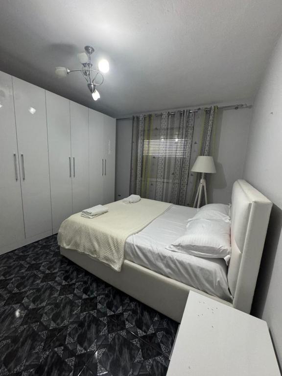 a bedroom with a large bed and white cabinets at Duomo Apartament in Shkodër