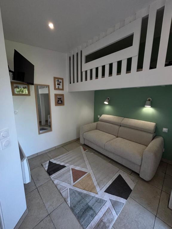 a living room with a couch and a tv at Le Nid d'escale in Tillé