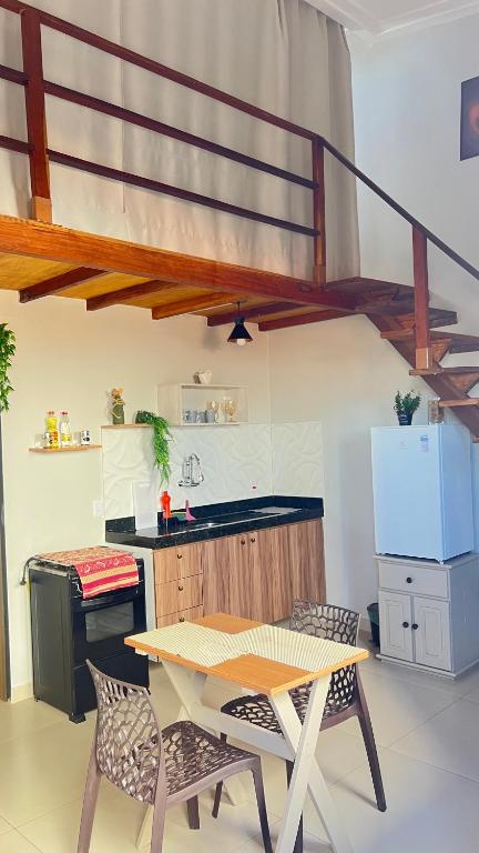 a kitchen with a table and two chairs and a counter at Apt estiloso 03 in Paragominas