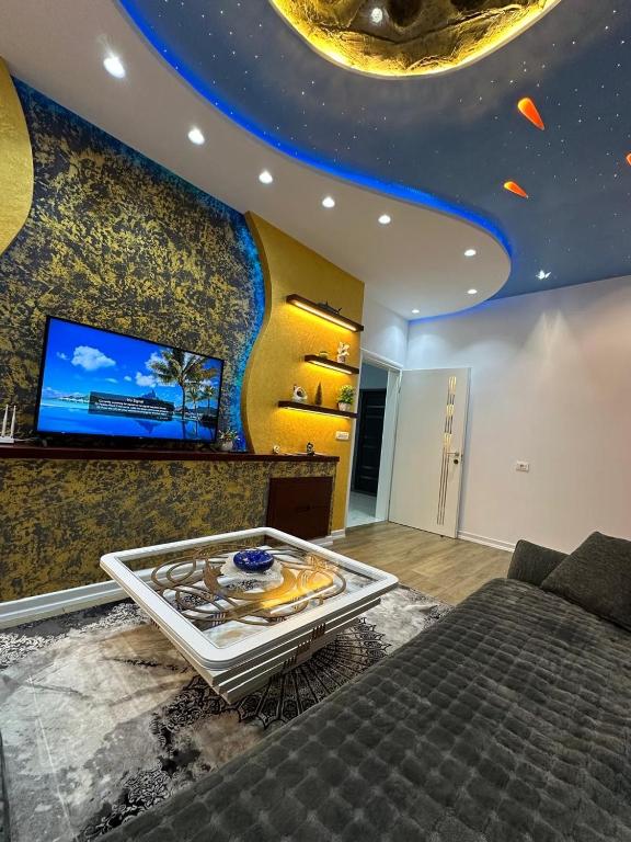 a living room with a bed and a flat screen tv at Prive Home in Maliq