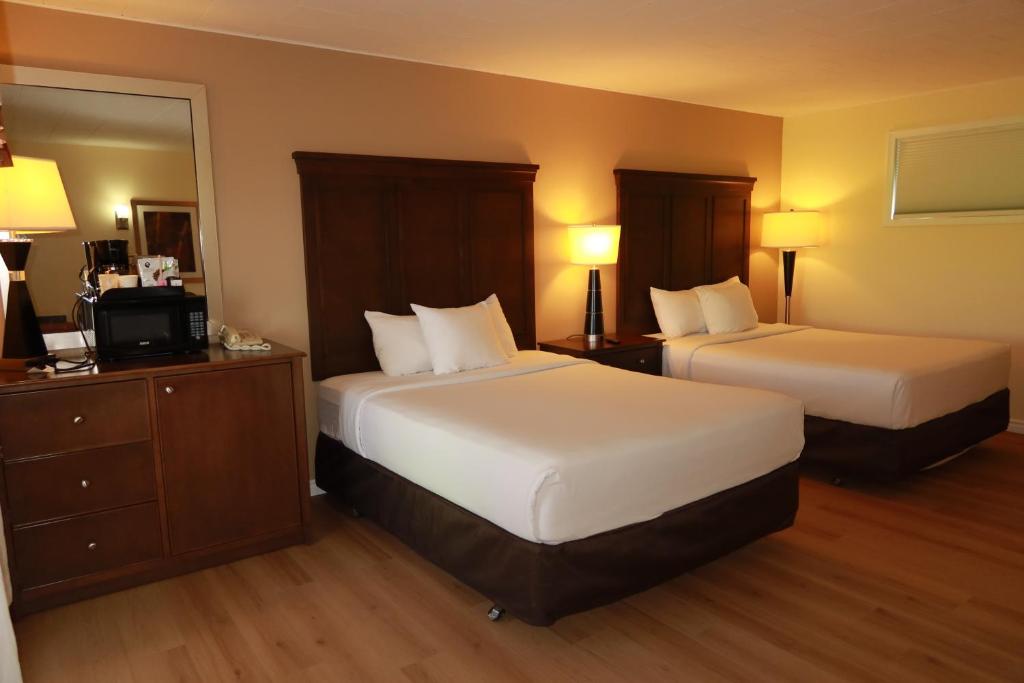 a hotel room with two beds and a mirror at Carolyn Beach Inn in Thessalon
