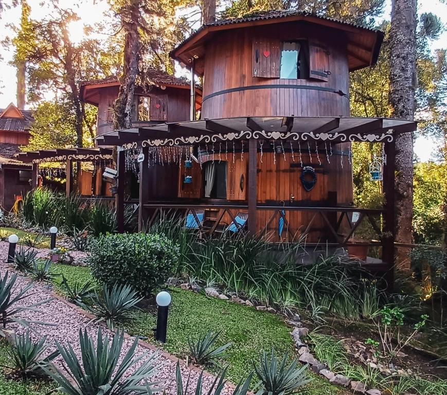 a tree house in the middle of a garden at Chalé Temático em Pipa de Vinho - Parada da Pipa Chalés in Canela
