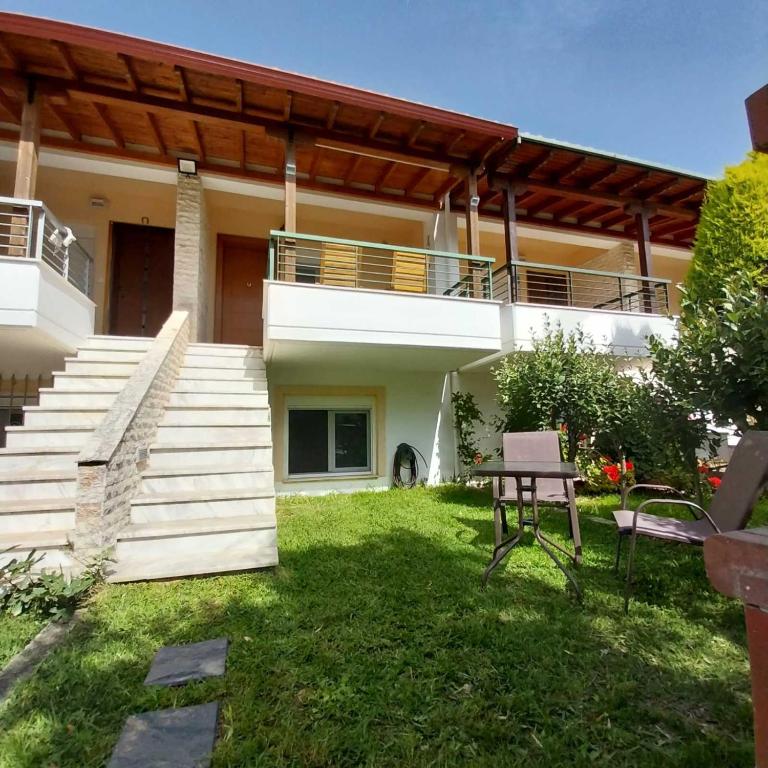 a house with a patio and a table in the yard at Olive Tree Villa in Nikiti