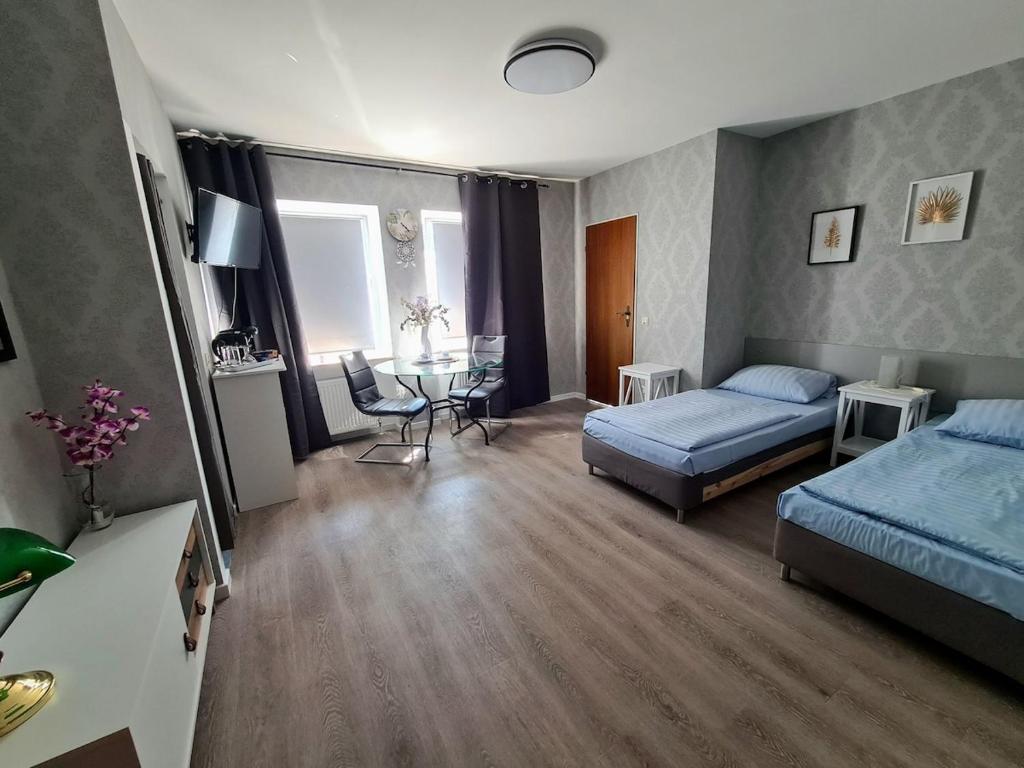 a bedroom with a bed and a table in it at Gemütliche Apartments in Bendorf