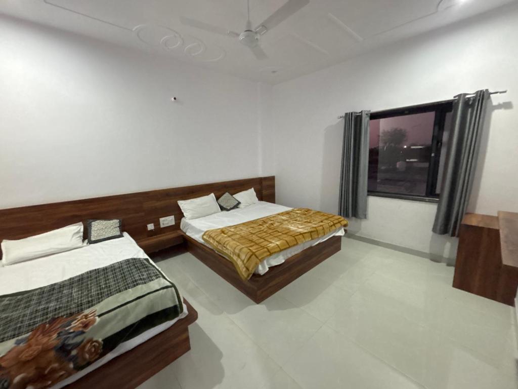 a bedroom with two beds and a tv in it at Lord Krishna hotel in Khātu