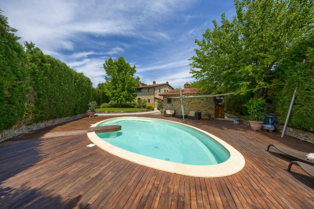 a large swimming pool on a wooden deck at Mhateria Relais - Relax in Villa con Piscina in Toscana in Rignano sullʼArno