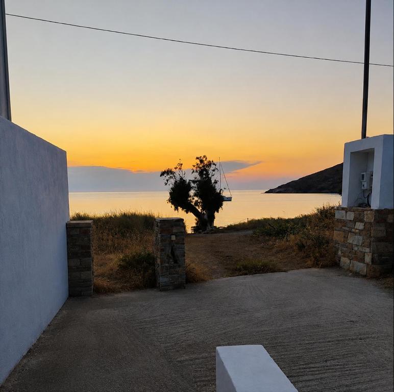 a view of the sunset from a house with a bench at Serene Stay Kythnos in Flampouria
