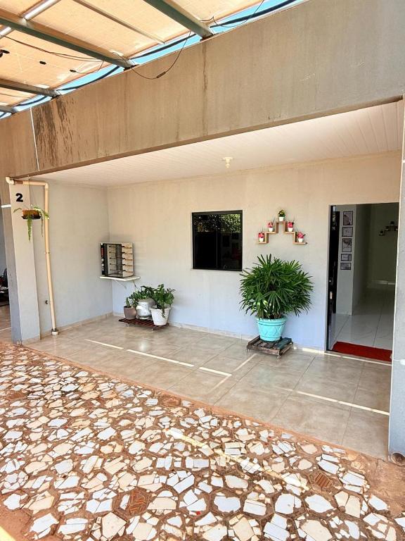 a large room with potted plants and a flat screen tv at Apartamento do Graf 2 in Sorriso
