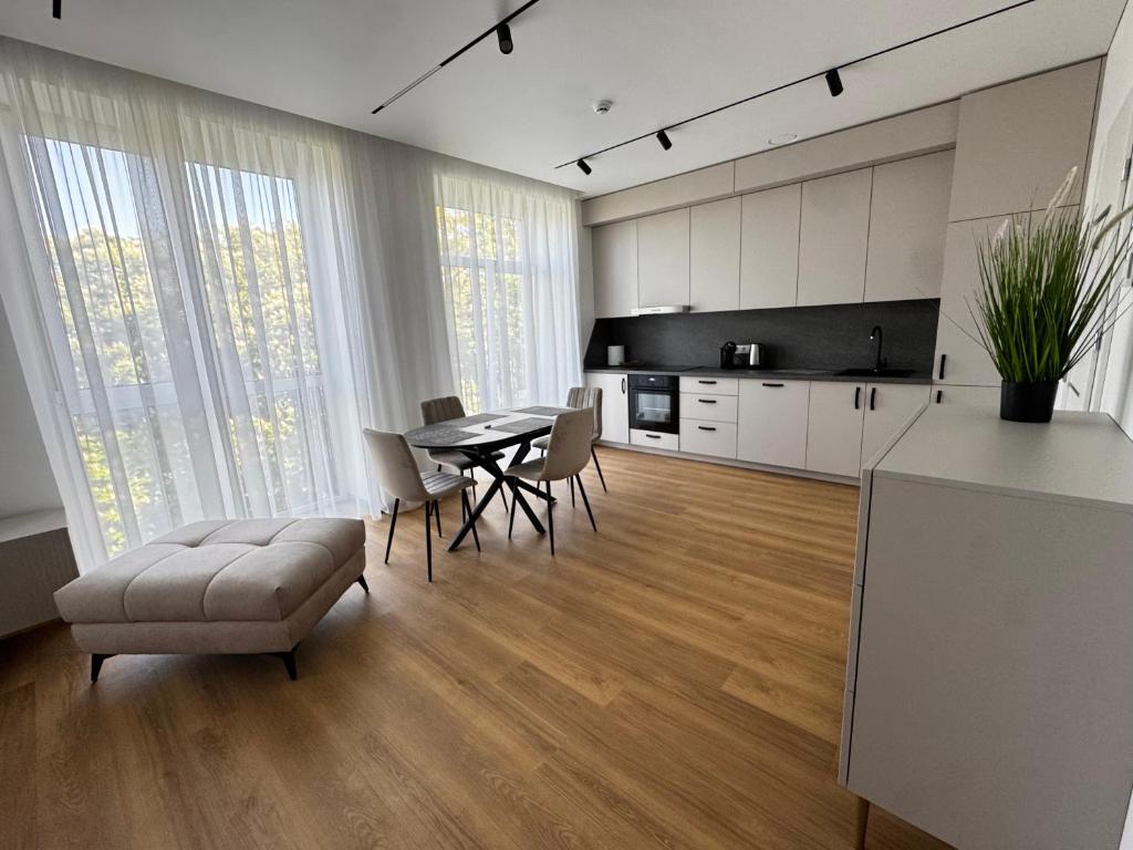 a kitchen and dining room with a table and chairs at Apartment in the city center near park and river 26 in Marijampolė