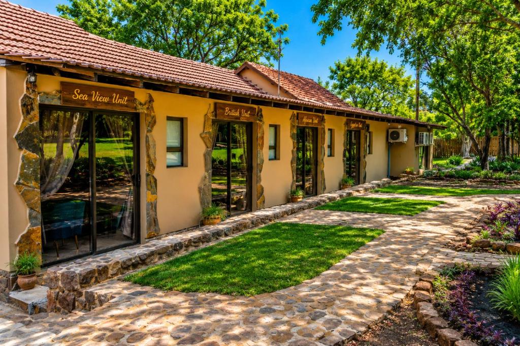 a house with a garden in front of it at Hartbeespoort - El-Tsuri Guest Resort in Hartbeespoort