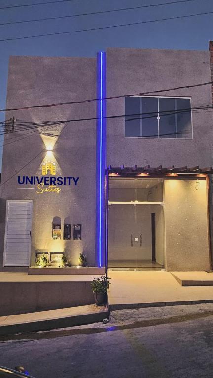 a store with a blue light on the side of a building at University Suítes in Carmópolis