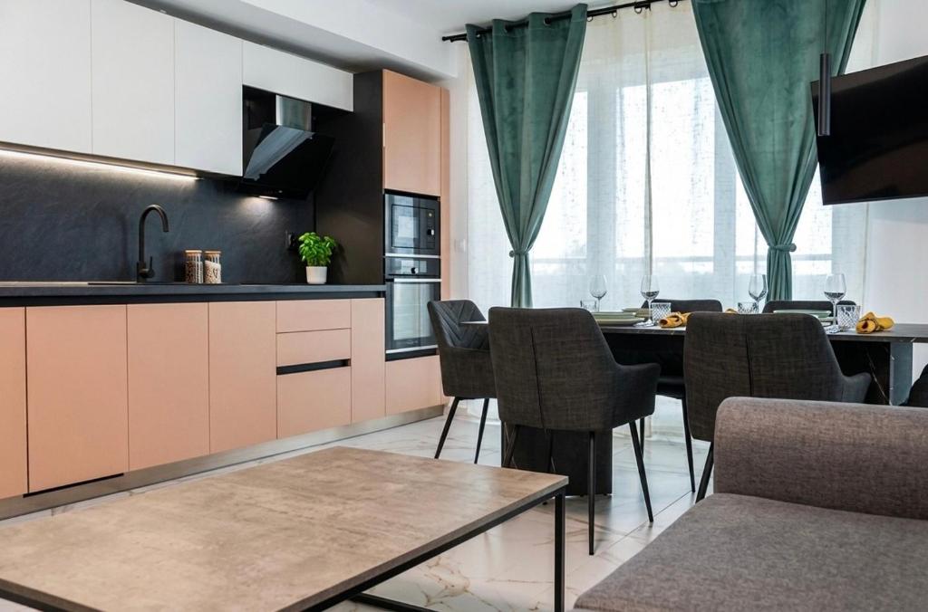 a kitchen with a table and chairs in a room at Blu Riviera Deluxe in Ahtopol