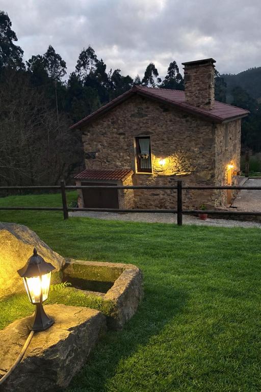 a light in front of a stone house at A casiña do Rieiro in San Pelayo