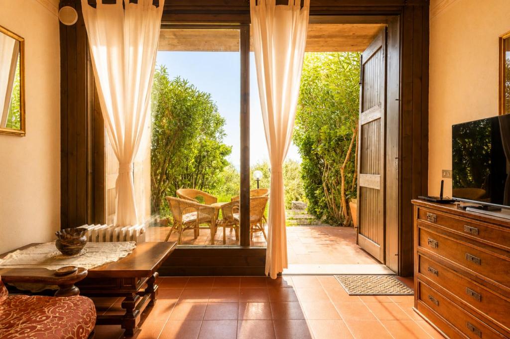 a living room with a door open to a patio at La Cami in Torri del Benaco