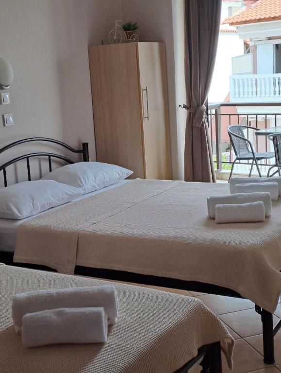 two beds in a hotel room with towels on them at House Psichoula in Sarti