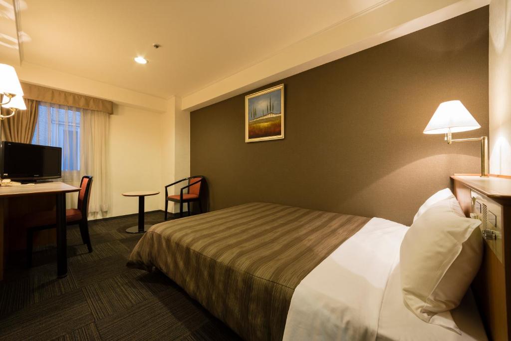 Postel nebo postele na pokoji v ubytování Ark Hotel Osaka Shinsaibashi -ROUTE INN HOTELS-