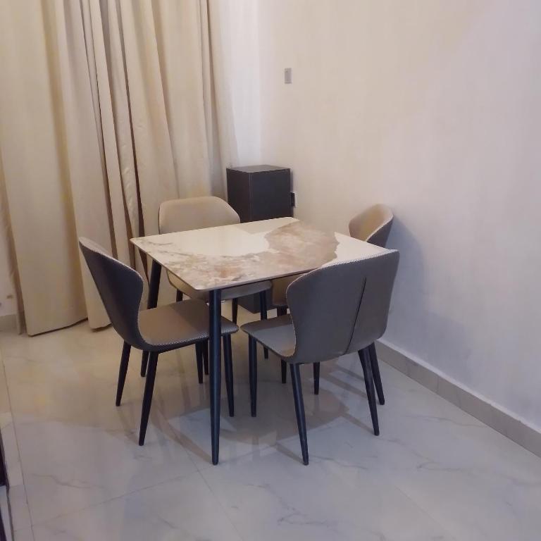 a table and chairs in a room at Bluetel Hotel and Suites Limited in Sapele