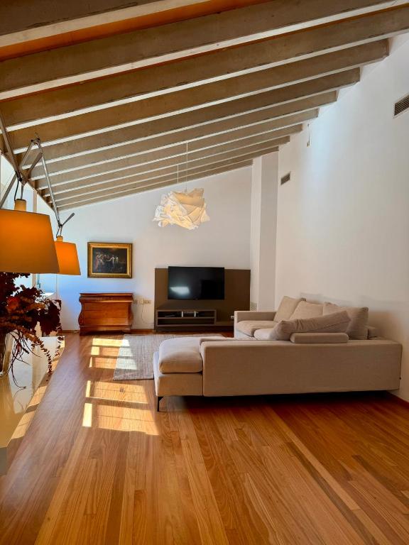 a living room with a couch and a flat screen tv at La Força Penthouse in Girona