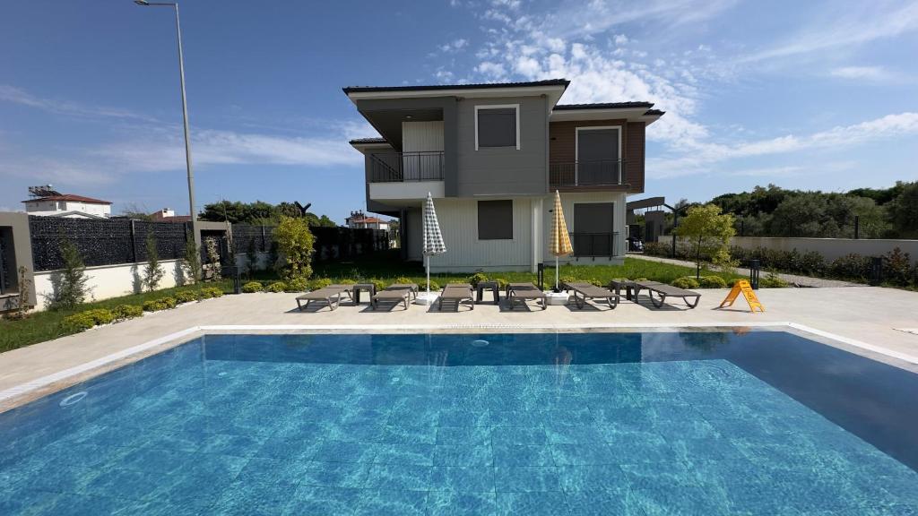a villa with a swimming pool in front of a house at Nest Park Side in Side