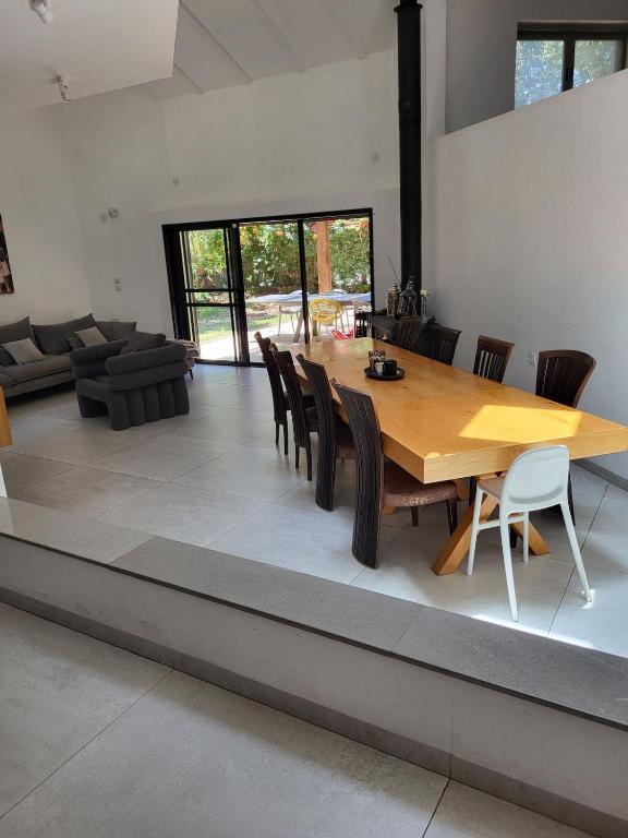 a dining room with a wooden table and chairs at Garden villa Raanana in Ra‘ananna
