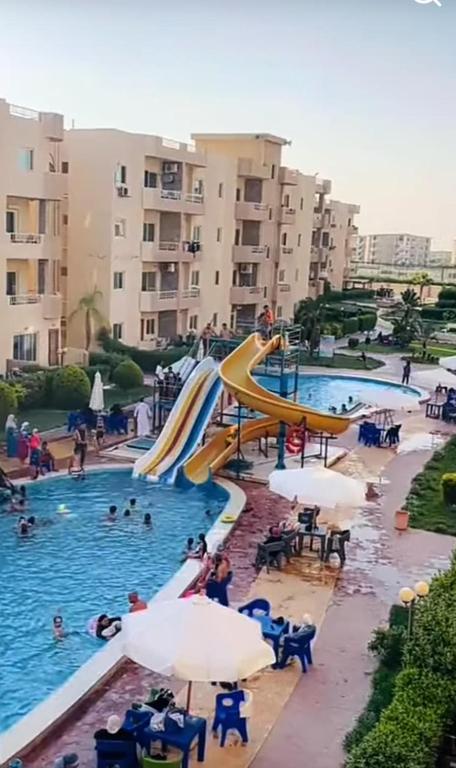 a swimming pool with a slide in a resort at Tahiti North coast kilo 62 in Borg El Arab