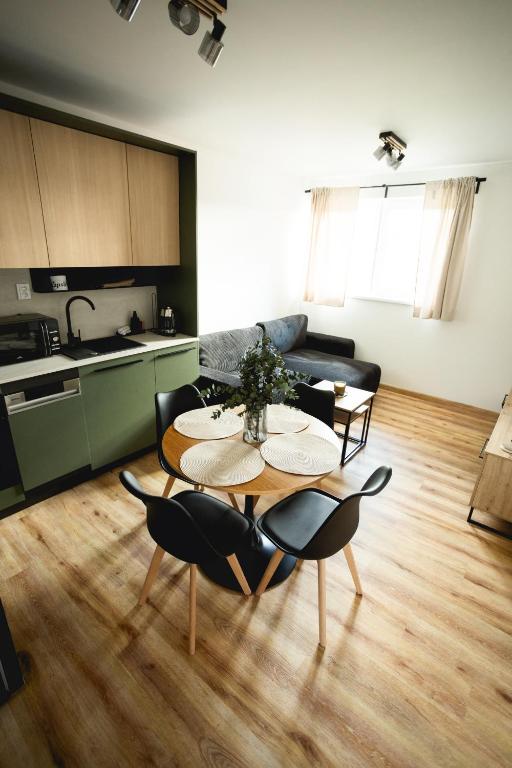 a kitchen and a living room with a table and chairs at Malé Lipno 1085 in Černá v Pošumaví