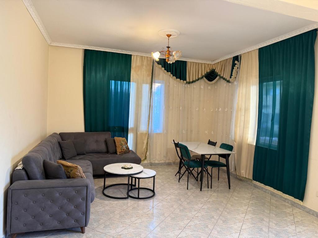 a living room with a couch and a table at Vogli's House Apartments & Rooms in Durrës