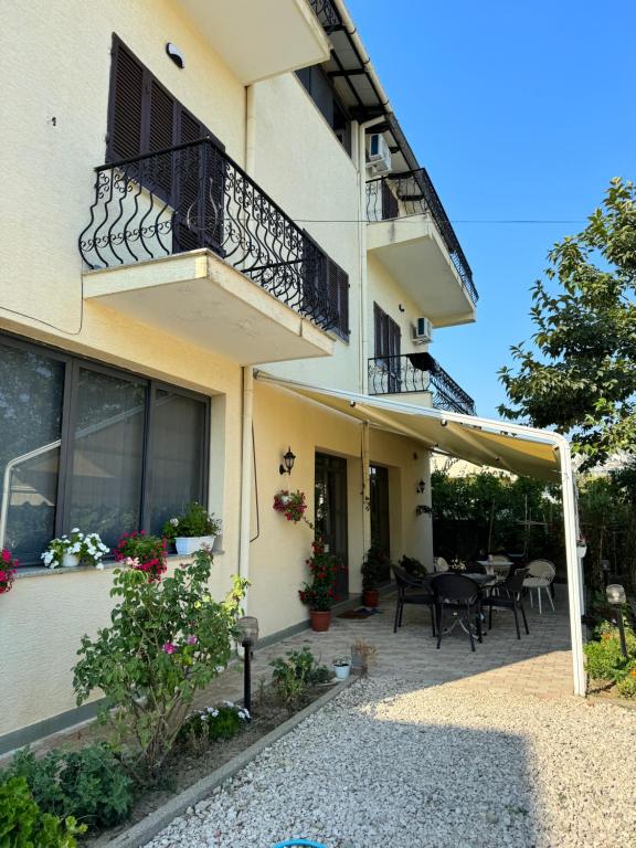 a building with a patio with tables and chairs at Villa Emma Durrës in Durrës