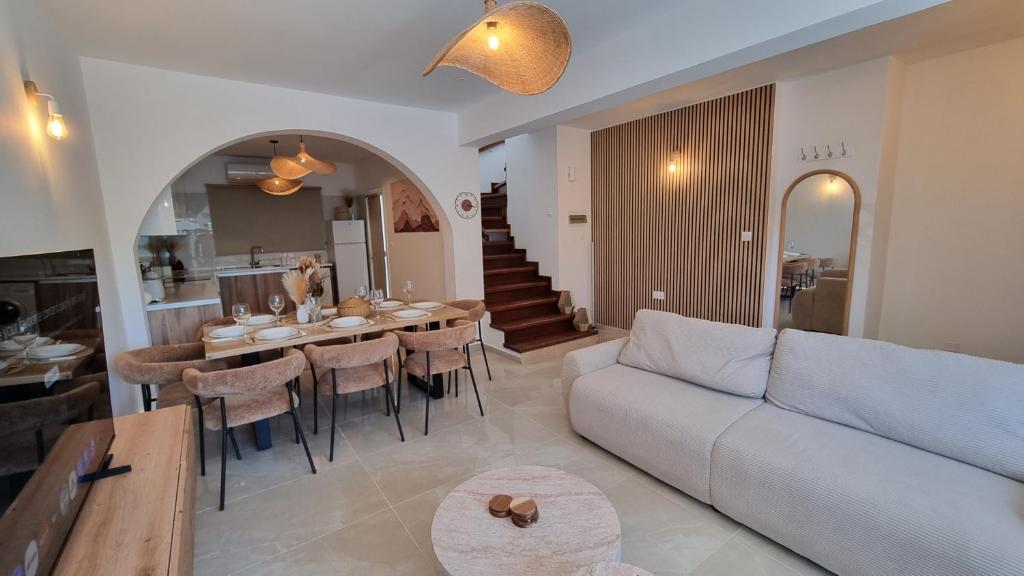 a living room with a couch and a table with chairs at Nerina 3 Luxury Villa in Paphos