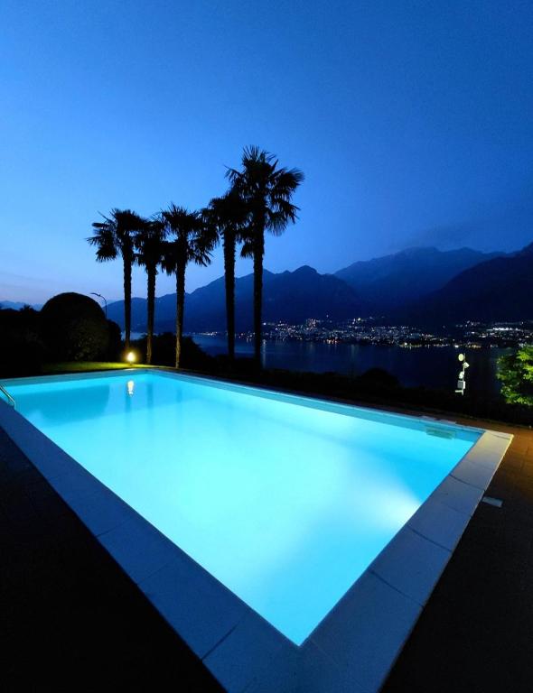 ein Swimmingpool mit Palmen bei Nacht in der Unterkunft Villa Maria in Onno