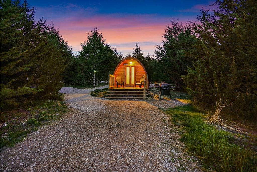 a cabin in the middle of a forest at sunset at The Cranny at Kimberly Creek Retreat in Ashland