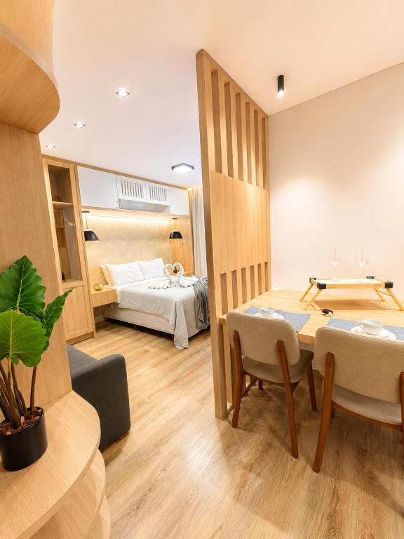 a room with a bed and a table and chairs at apartamento vitória 101 in Pomerode