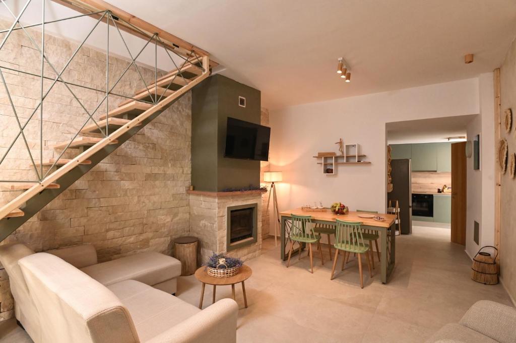 a living room with a couch and a table and a fireplace at Little escape in episkopi-heraklion